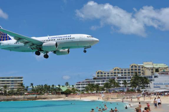 Avião de grande porte passa sobre Maho Bay, praia de Sint Maarten - Caribe, fazendo a alegria da galera!